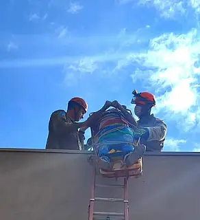 Homem sofre descarga elétrica e é resgatado pelos Bombeiros em telhado de barracão